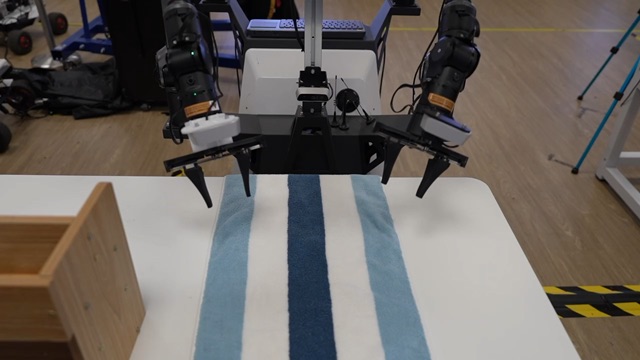 A robot folding a blue towel